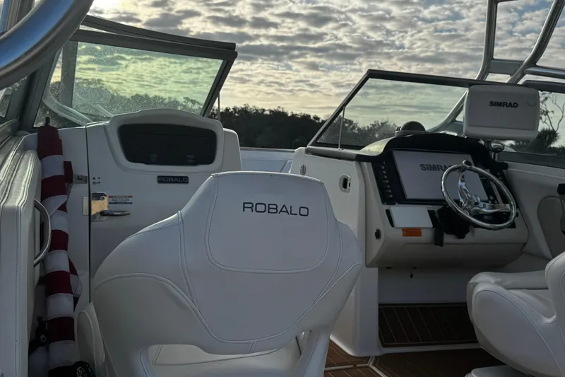 Slide: The Image of 2016 Robalo R247 Dual Console boat interior with steering wheel and dashboard. - 5