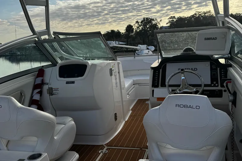 Slide: The Image of 2016 Robalo R247 Dual Console boat interior with steering wheel and seating. - 7