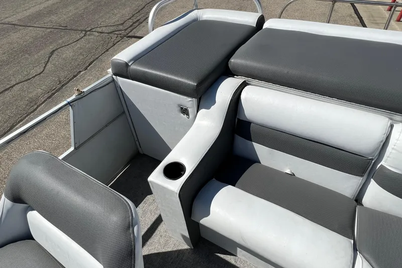 Slide: The Image of 1992 Northwoods Fun Deluxe Pontoon interior with gray seating and cup holder. - 12