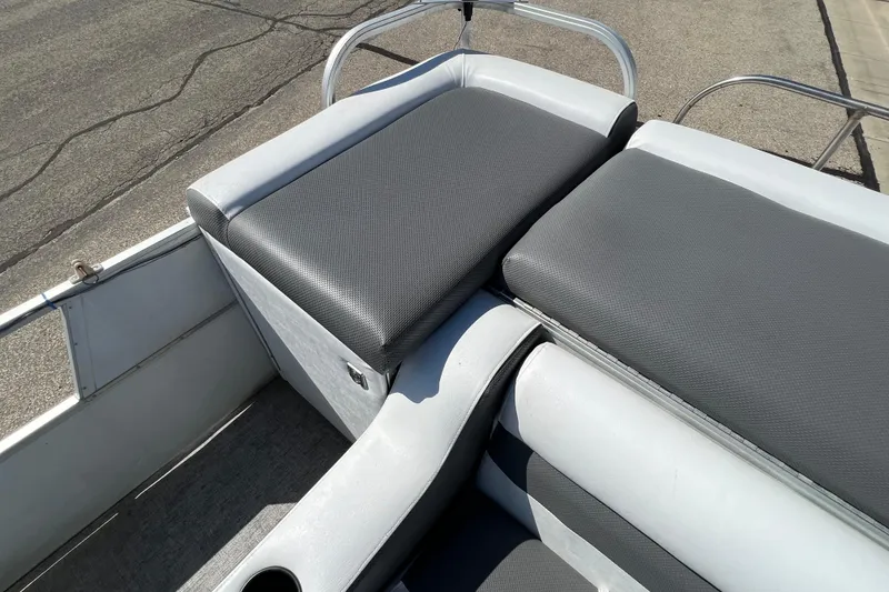 Slide: The Image of 1992 Northwoods Fun Deluxe Pontoon with gray cushioned seating, docked on pavement. - 18