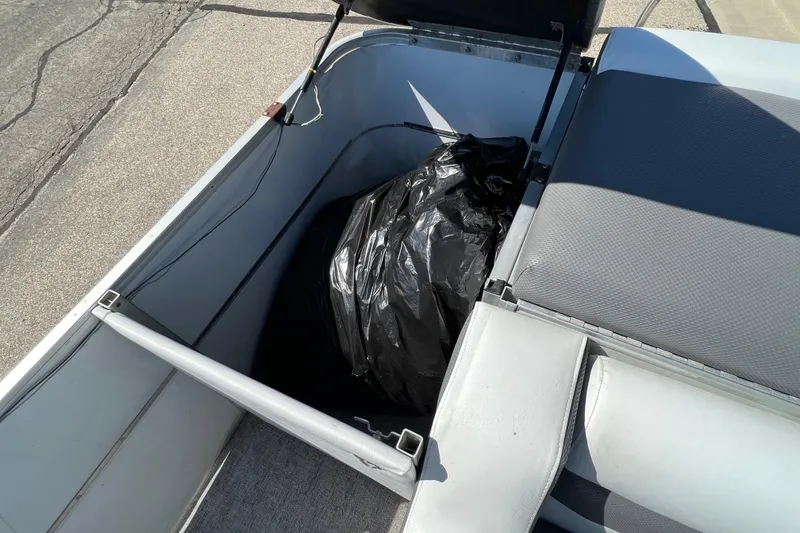 Slide: The Image of 1992 Northwoods Fun Deluxe Pontoon storage compartment with black bag inside. - 19