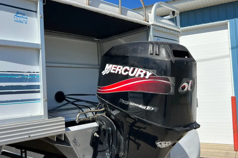 Slide: The Image of 1992 Northwoods Fun Deluxe Pontoon with Mercury outboard motor in a sunny setting. - 5