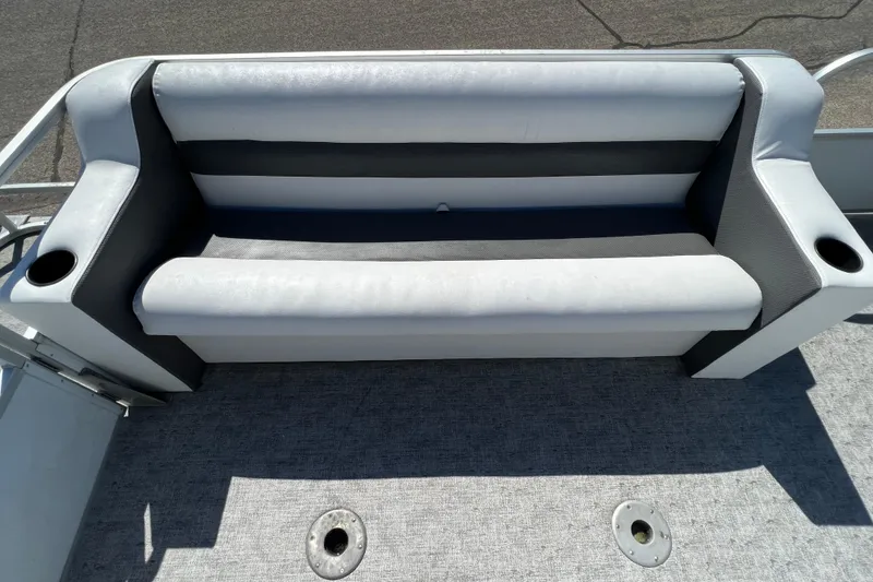 Slide: The Image of 1992 Northwoods Fun Deluxe Pontoon seat with cup holders, gray upholstery, and textured flooring. - 7