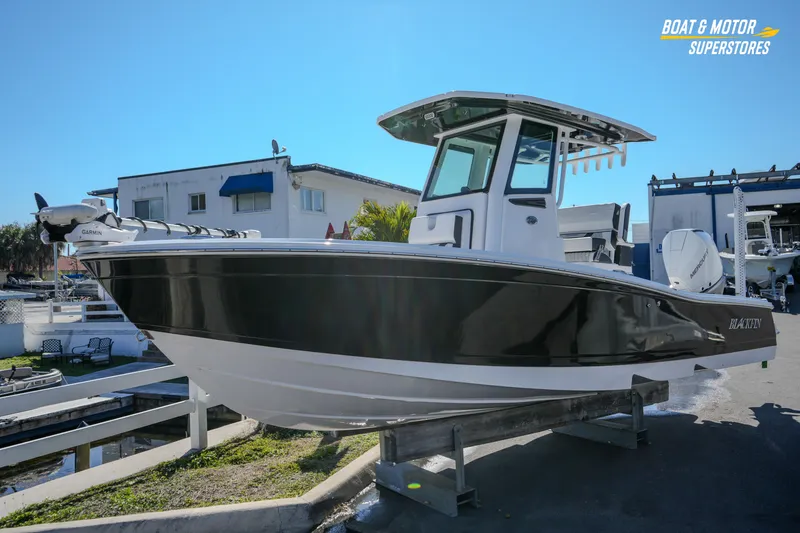 Slide: The Image of 2025 Blackfin 262 HB boat displayed at a dealership under clear blue skies. - 10