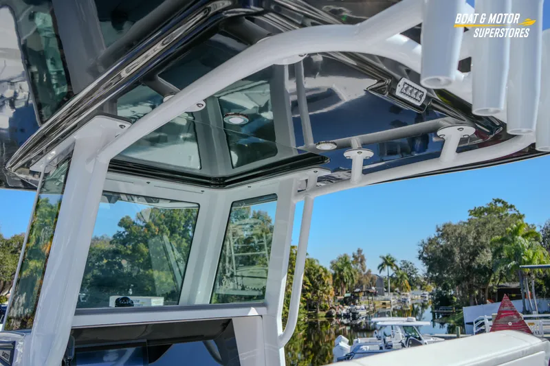 Slide: The Image of 2025 Blackfin 262 HB boat with sleek design and modern features, docked near lush greenery. - 20