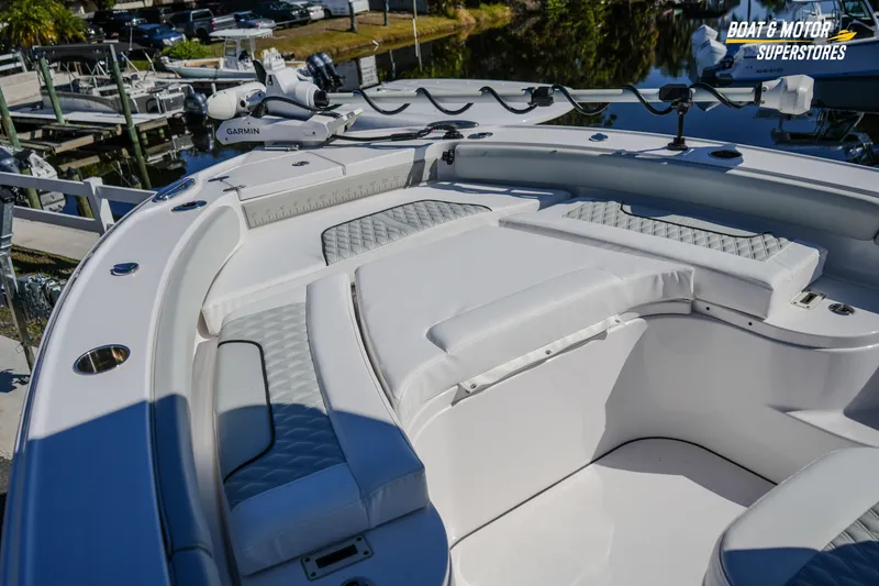 Slide: The Image of 2025 Blackfin 262 HB boat interior with cushioned seating and Garmin equipment at a marina. - 36