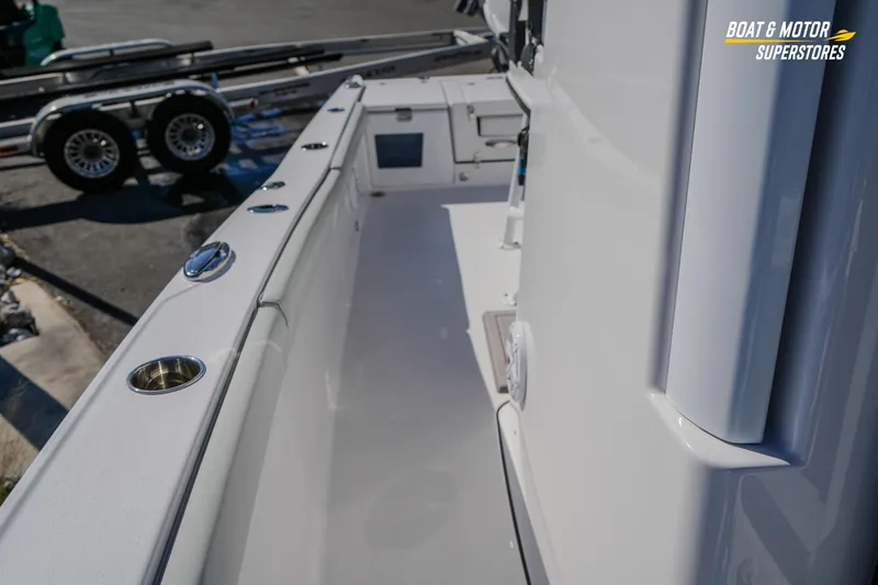 Slide: The Image of 2025 Blackfin 262 HB boat deck with cup holders and trailer in background. - 39