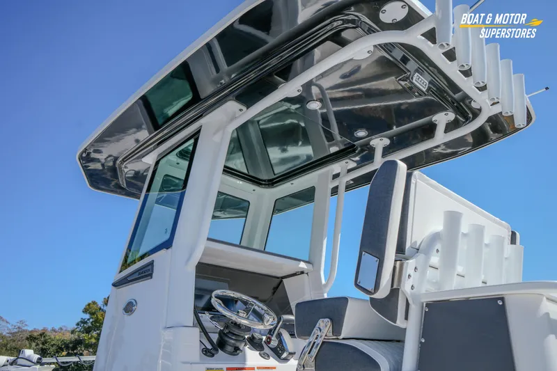 Slide: The Image of 2025 Blackfin 262 HB boat helm with T-top and seating against blue sky. - 8