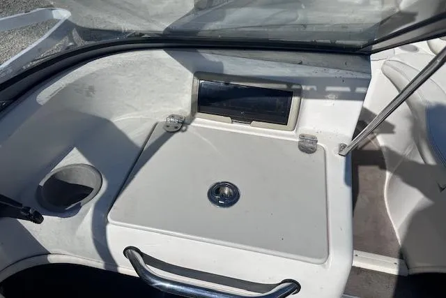 Slide: The Image of 2011 Stingray 185 LS/LX boat interior with storage compartment and cup holder. - 14