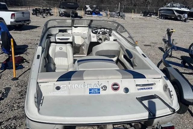 Slide: The Image of 2011 Stingray 185 LS/LX boat with white interior, parked outdoors on gravel. - 5