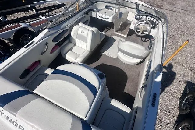 Slide: The Image of 2011 Stingray 185 LS/LX boat interior with seating and dashboard, parked on gravel. - 6