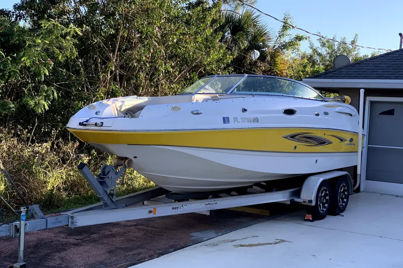 The Image of 2006 Chaparral Sunesta 236 boat on trailer, displayed outdoors under clear blue sky. - 0