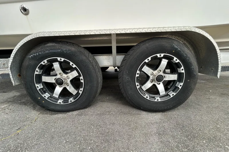 Slide: The Image of Trailer wheels of a 2006 Chaparral Sunesta 236 boat on pavement. - 105