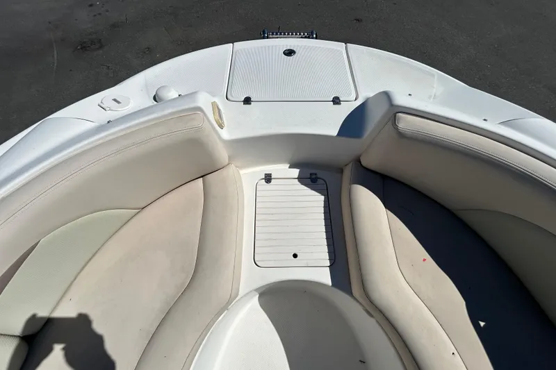 Slide: The Image of 2006 Chaparral Sunesta 236 boat interior with white seating and storage compartment. - 15