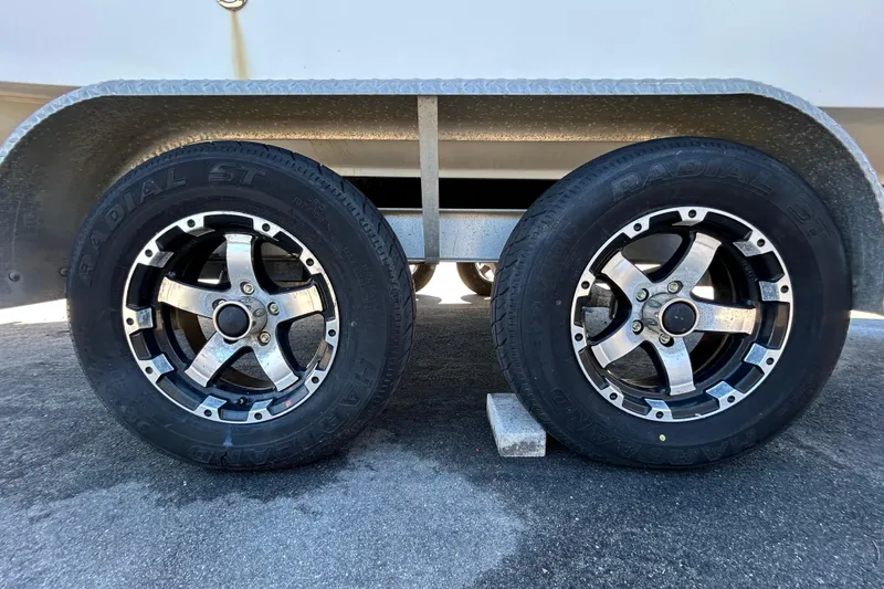 Slide: The Image of Trailer wheels of a 2006 Chaparral Sunesta 236 boat on pavement. - 27