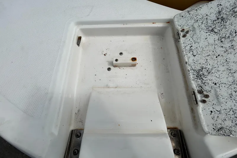 Slide: The Image of 2006 Chaparral Sunesta 236 boat compartment with open hatch, showing wear and rust. - 34