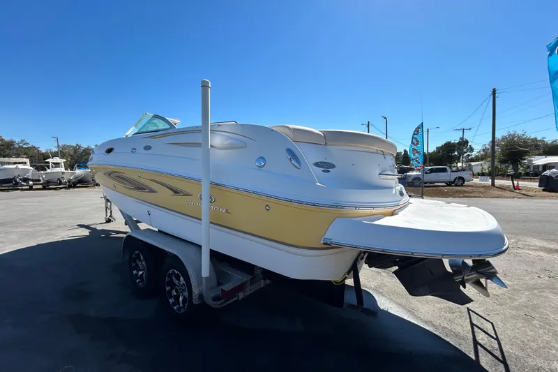 Slide: The Image of 2006 Chaparral Sunesta 236 boat on trailer, parked outdoors under clear blue sky. - 5