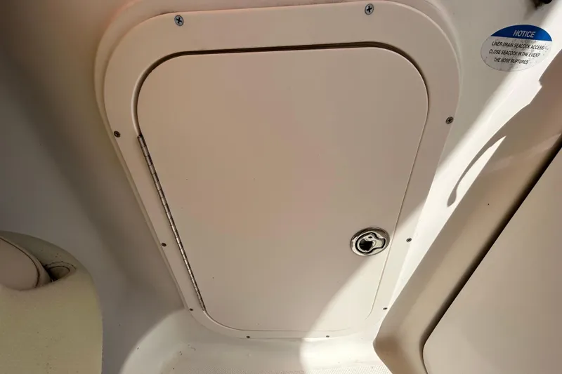 Slide: The Image of 2006 Chaparral Sunesta 236 boat storage compartment with lock and notice label. - 50