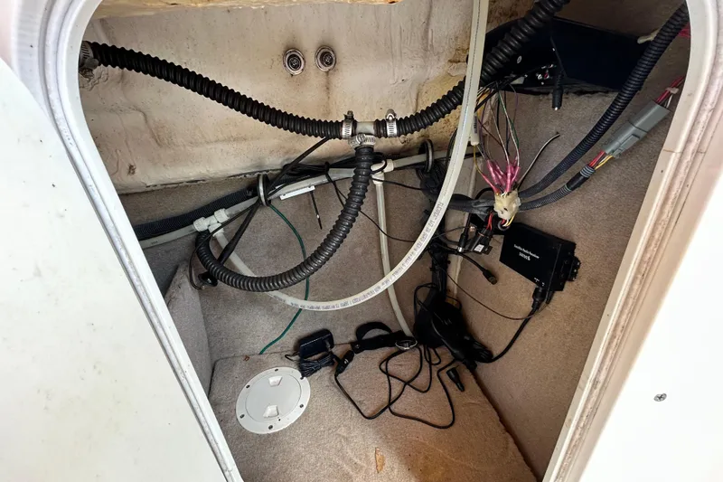 Slide: The Image of 2006 Chaparral Sunesta 236 boat interior wiring and components in storage compartment. - 52