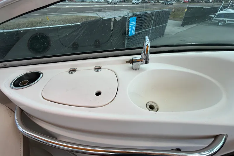 Slide: The Image of 2006 Chaparral Sunesta 236 boat sink area with faucet and cup holder. - 53