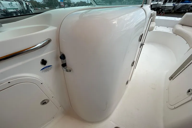 Slide: The Image of 2006 Chaparral Sunesta 236 boat interior, featuring white seating and storage compartments. - 56