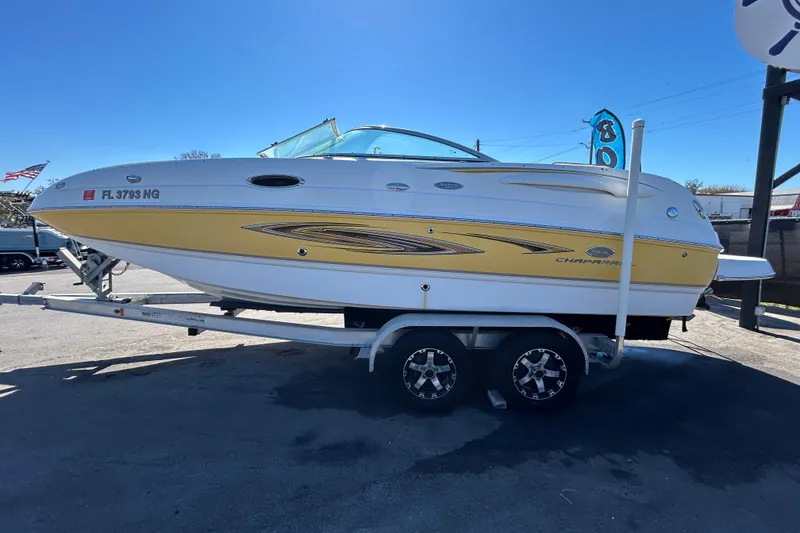Slide: The Image of 2006 Chaparral Sunesta 236 boat on trailer, yellow and white design, clear sky background. - 6