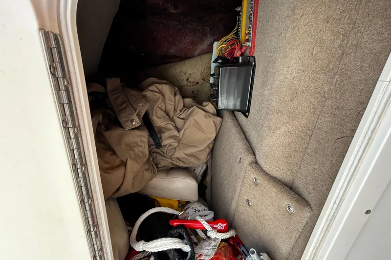 Slide: The Image of 2006 Chaparral Sunesta 236 storage compartment with ropes, jacket, and electrical panel. - 61