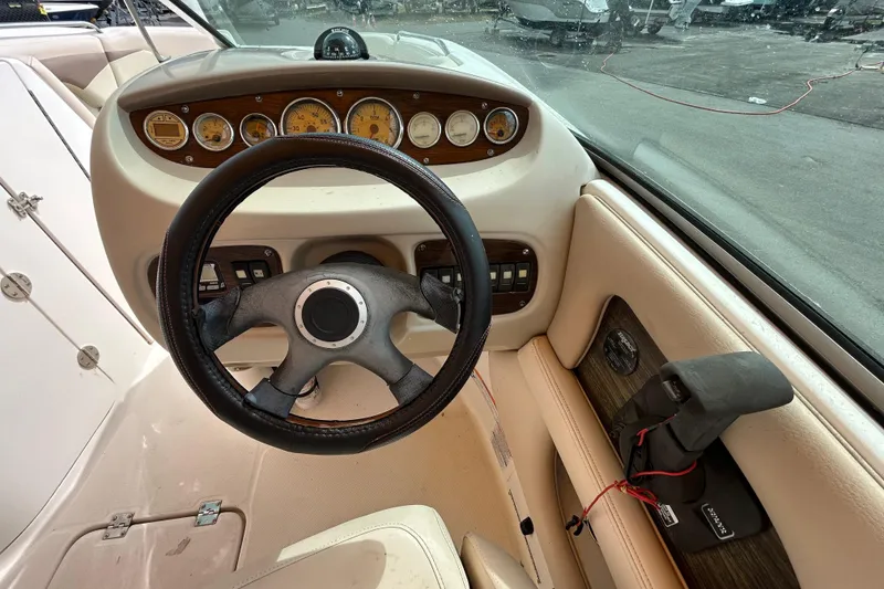 Slide: The Image of 2006 Chaparral Sunesta 236 boat dashboard with steering wheel and gauges. - 62