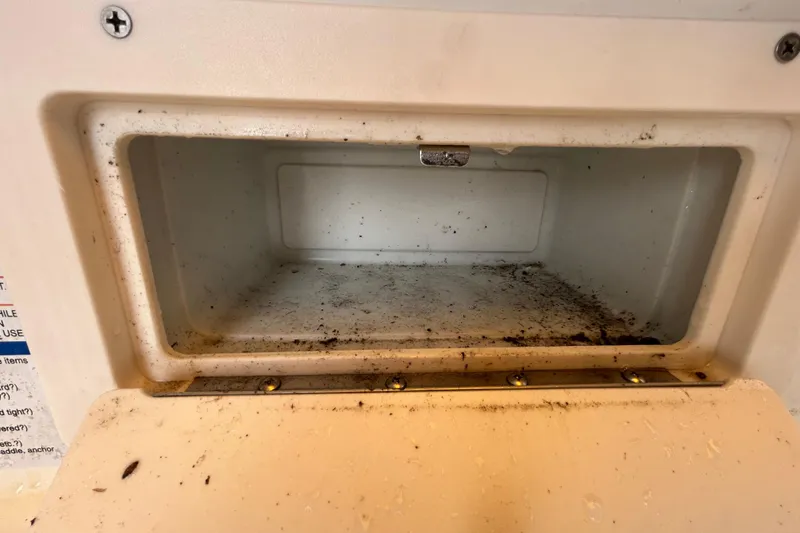 Slide: The Image of Storage compartment of a 2006 Chaparral Sunesta 236 boat, showing dirt and wear. - 66