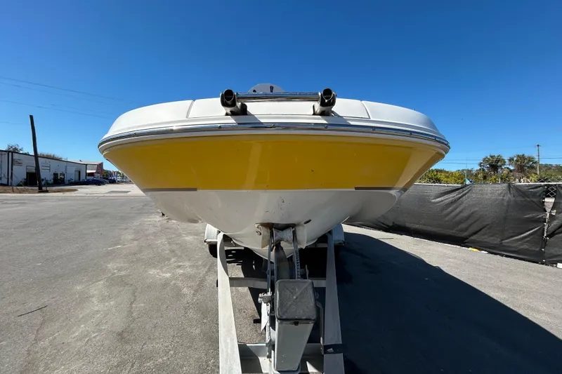 Slide: The Image of 2006 Chaparral Sunesta 236 boat on trailer, yellow hull, clear blue sky background. - 9