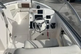 Slide: The Image of 2023 Cobia 220 Dual Console boat interior with steering wheel and dashboard controls. - 8