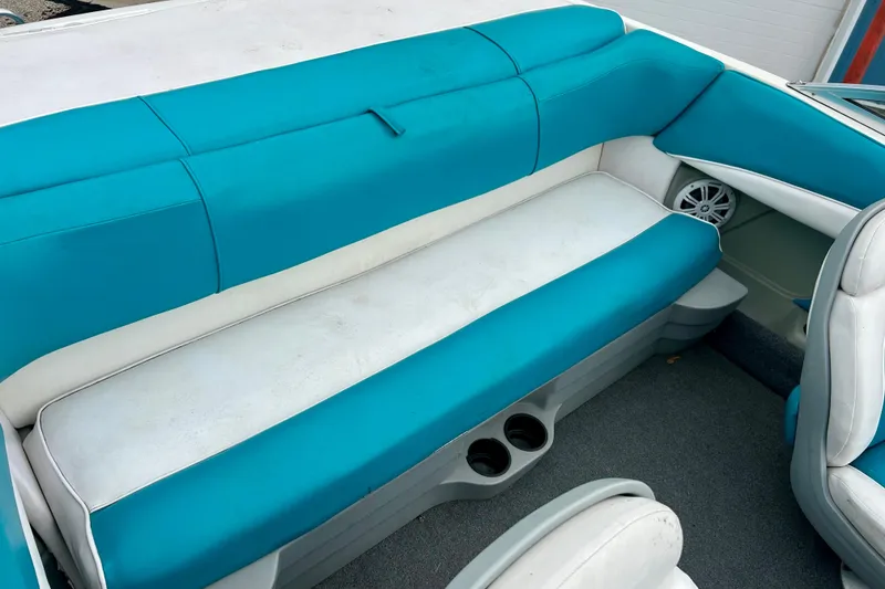 Slide: The Image of 1993 Glastron SSV 175 boat interior with teal and white seating, cup holders, and speaker. - 7