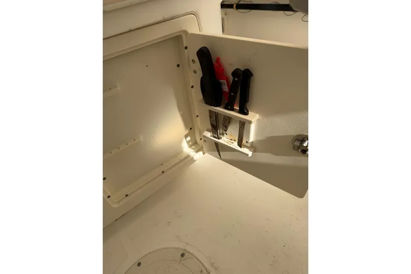 Slide: The Image of Storage compartment with tools on a 2004 Boston Whaler 320 Outrage boat. - 14