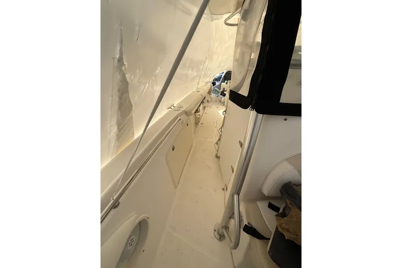 Slide: The Image of 2004 Boston Whaler 320 Outrage interior view, showcasing side walkway and seating area. - 16