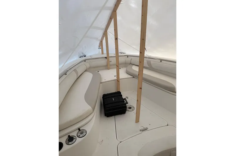 Slide: The Image of 2004 Boston Whaler 320 Outrage boat interior under protective cover, featuring seating and storage. - 3