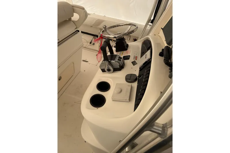Slide: The Image of 2004 Boston Whaler 320 Outrage helm with steering wheel and controls. - 9