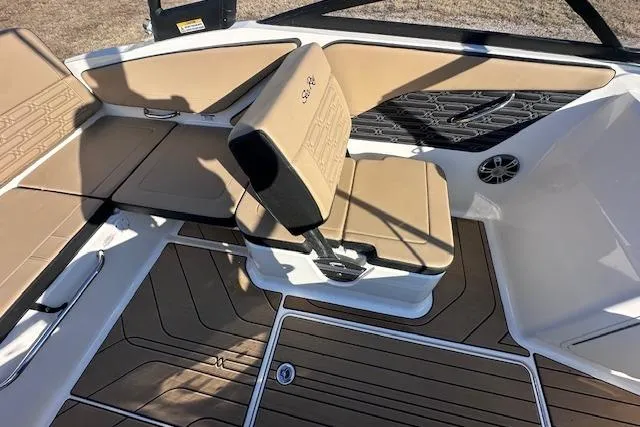 Slide: The Image of 2024 Sea Ray SPX 210 boat interior with tan seating and wood-patterned flooring. - 12