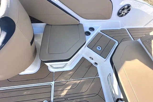 Slide: The Image of 2024 Sea Ray SPX 210 boat interior with tan seating and teak-style flooring. - 14