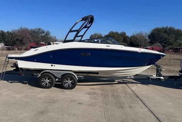 Slide: The Image of 2024 Sea Ray SPX 210 boat on trailer, blue and white design, parked outdoors. - 2