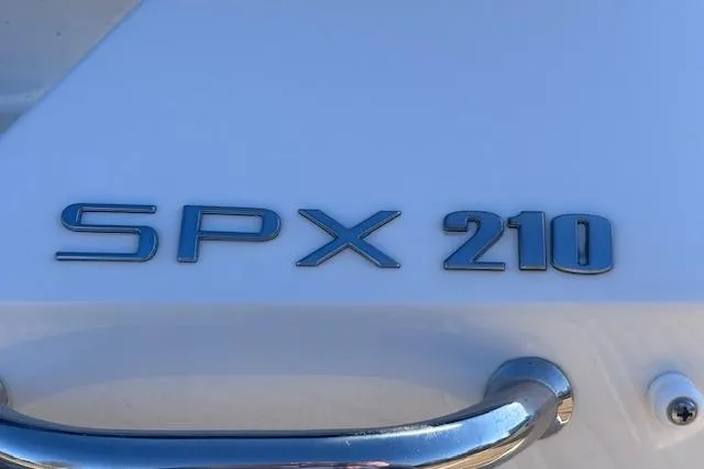 Slide: The Image of 2024 Sea Ray SPX 210 boat emblem on white surface with chrome handle. - 26