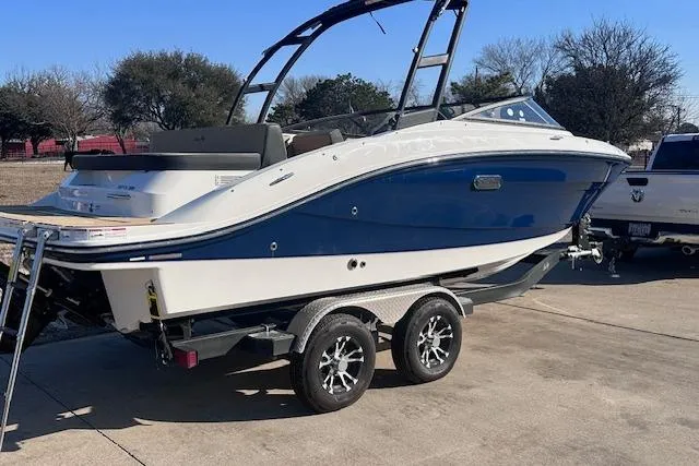 Slide: The Image of 2024 Sea Ray SPX 210 boat on trailer, blue and white design, parked outdoors. - 3