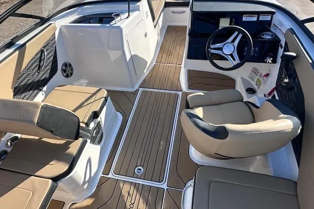 Slide: The Image of 2024 Sea Ray SPX 210 boat interior with tan seating and wood-style flooring. - 9
