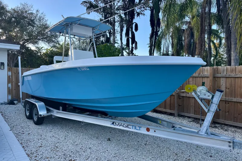 The Image of 2001 Contender 23 Open boat on trailer, parked under palm trees. - 0