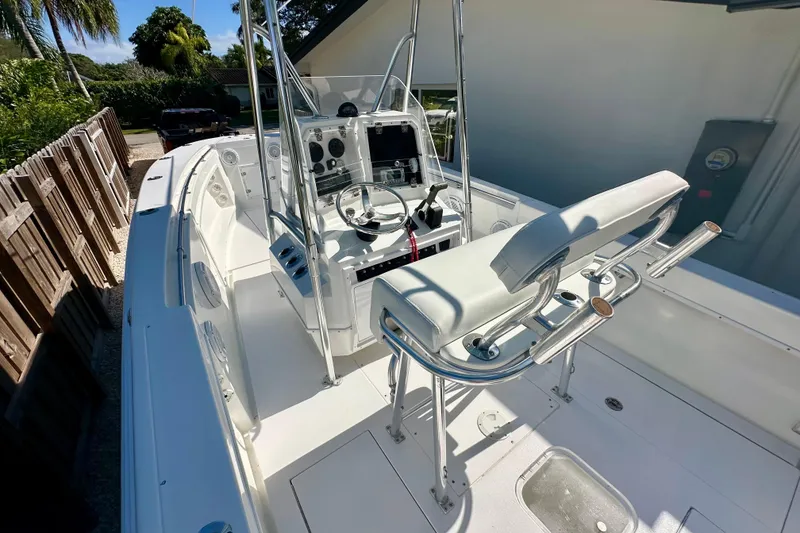 Slide: The Image of 2001 Contender 23 Open boat with T-top, parked outdoors near a house. - 16