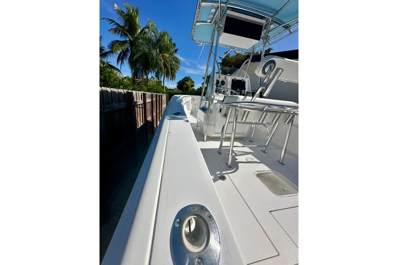 Slide: The Image of 2001 Contender 23 Open boat deck, featuring sleek white design and stainless steel railings. - 19