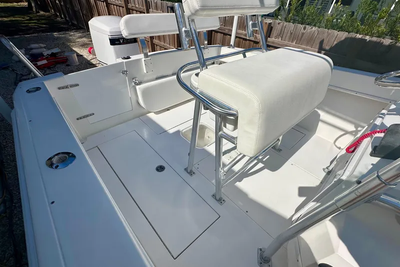 Slide: The Image of 2001 Contender 23 Open boat interior with console and seating, surrounded by lush greenery. - 23