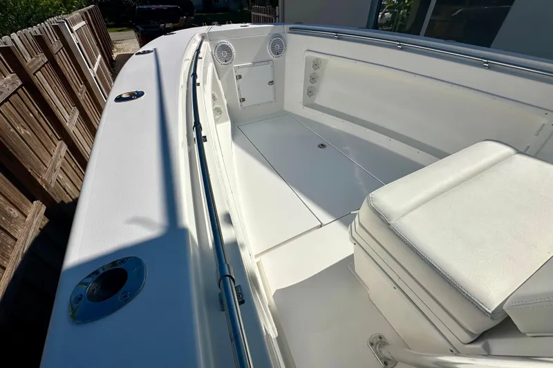 Slide: The Image of 2001 Contender 23 Open boat with T-top and helm, under clear blue sky. - 26