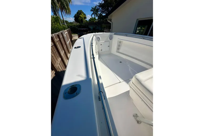 Slide: The Image of 2001 Contender 23 Open boat with T-top and helm, set against a sunny backdrop. - 27
