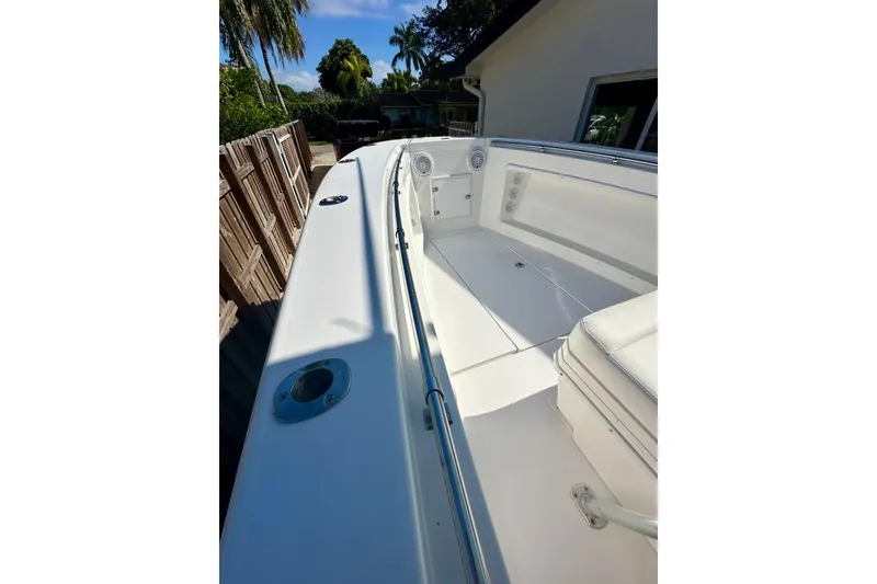 Slide: The Image of 2001 Contender 23 Open boat with blue canopy, steering console, and tropical background. - 28