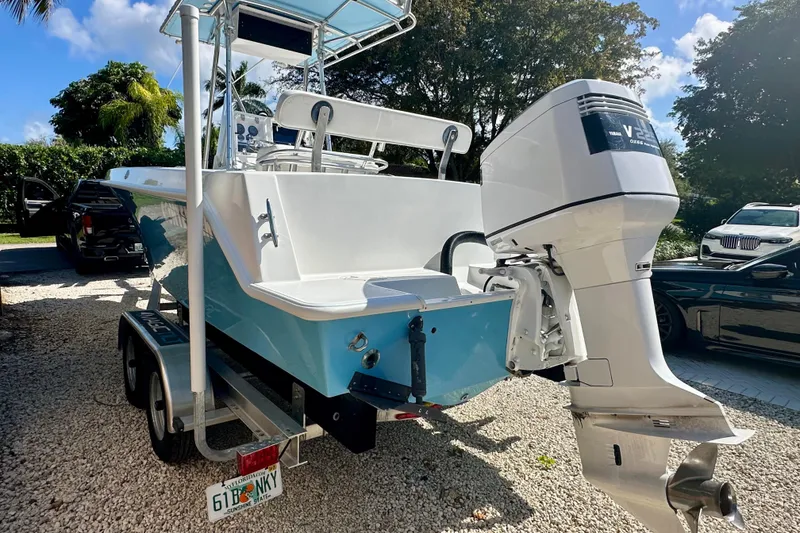 Slide: The Image of 2001 Contender 23 Open boat on trailer, blue hull, palm trees in background. - 7